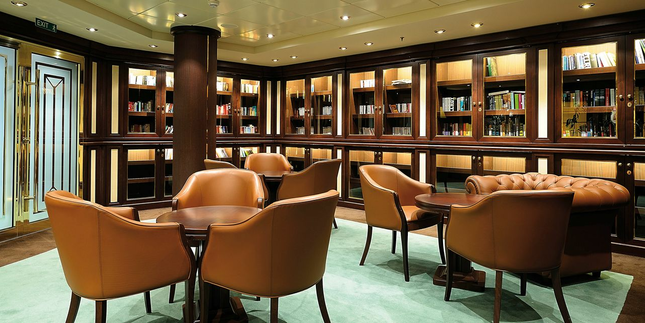 The onboard Library presents comfortable leather arm chairs and settees surrounded by a variety of books in a number of languages, along with board games and cards for passengers to enjoy